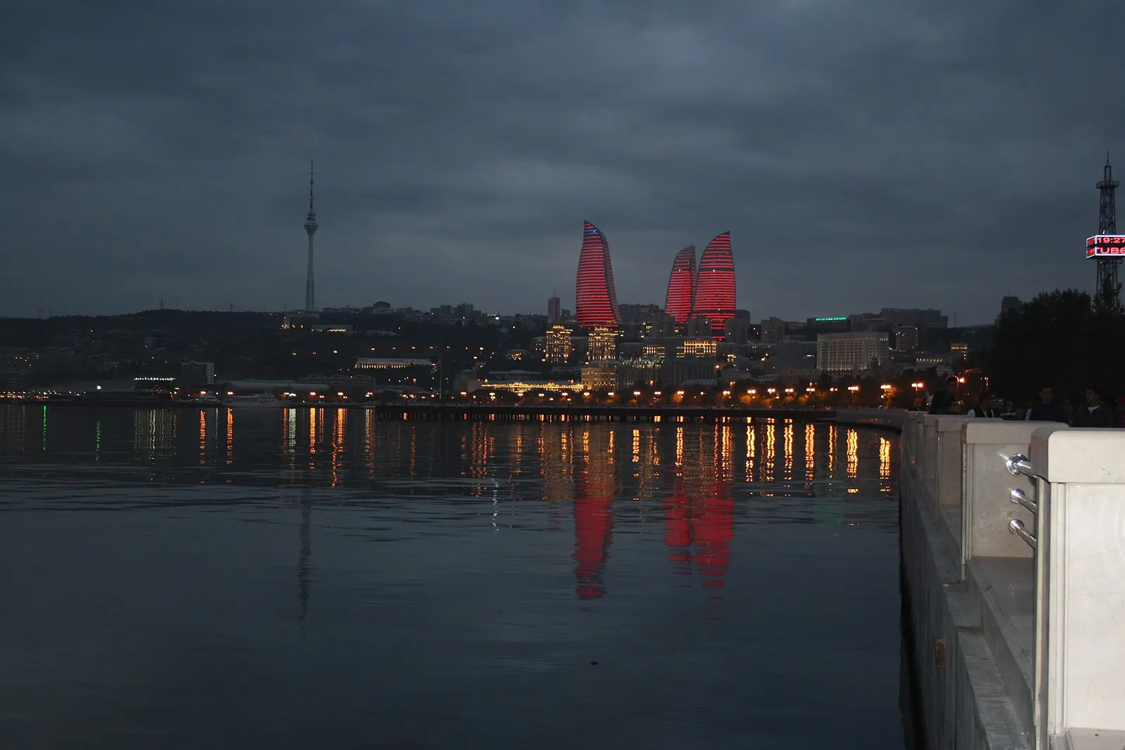 Baku wieczorem: podświetlone wieże Flame Towers odbite w wodzie Morza Kaspijskiego